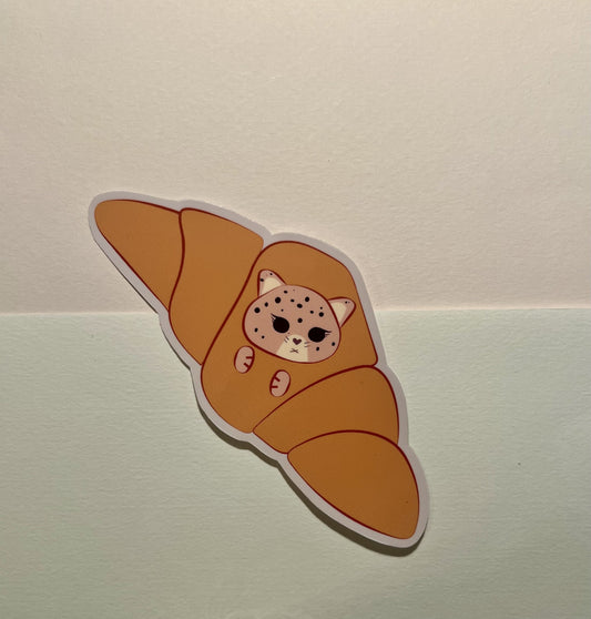 Sticker of a kawaii jaguar inside a croissant on a light background